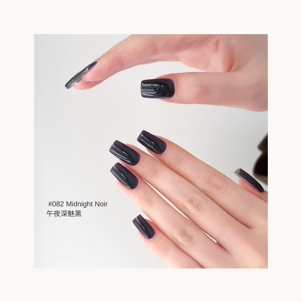A set of glossy deep black press-on nails in shade 082, shown on hands with a clean minimalist background.

