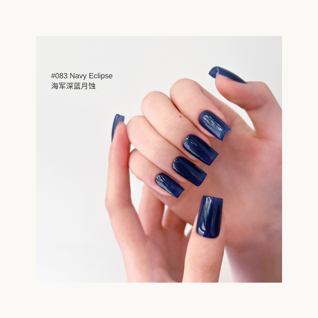 Smoky deep blue press-on nails in shade 084, shown on hands with a soft light background.

