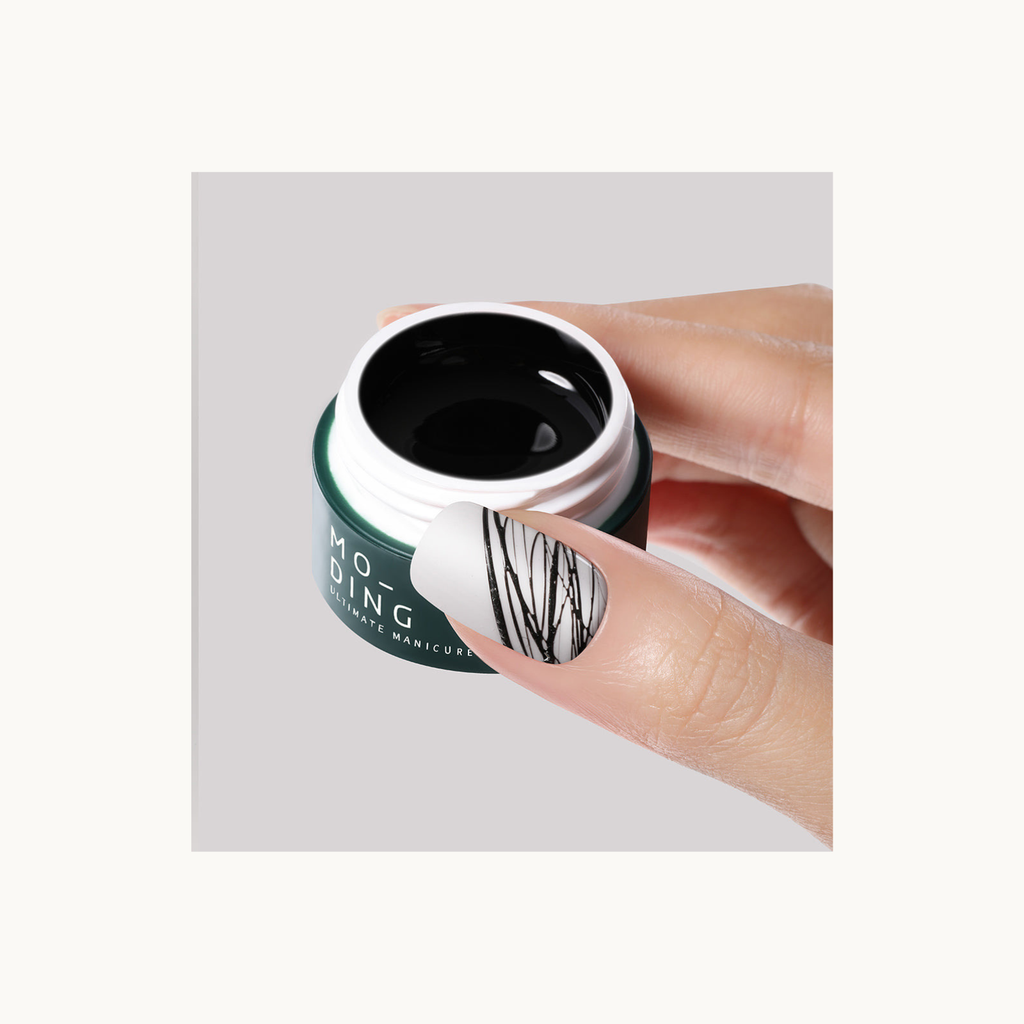 Close-up of MODING black drawing gel (spider gel) showing fine line nail art detailing on thumbnail