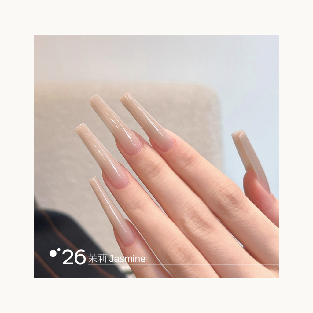 Long coffin-shaped nails painted in shade Q26 Jasmine, a soft beige nude gradient with a smooth glossy shine.