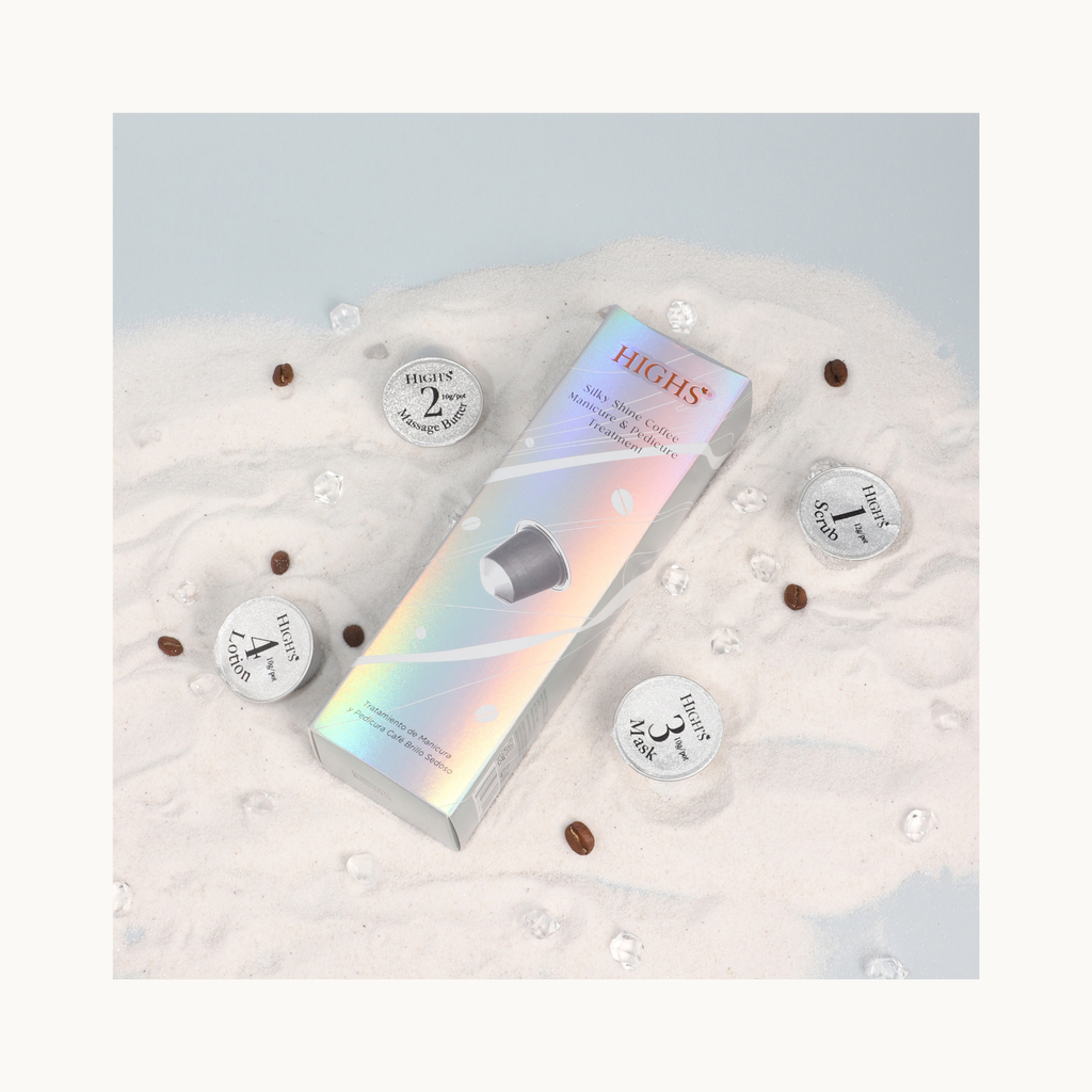 Flat lay of HIGHS Silky Shine Coffee Mani Pedi Treatment with all four step cups arranged on sand with coffee beans and crystals.