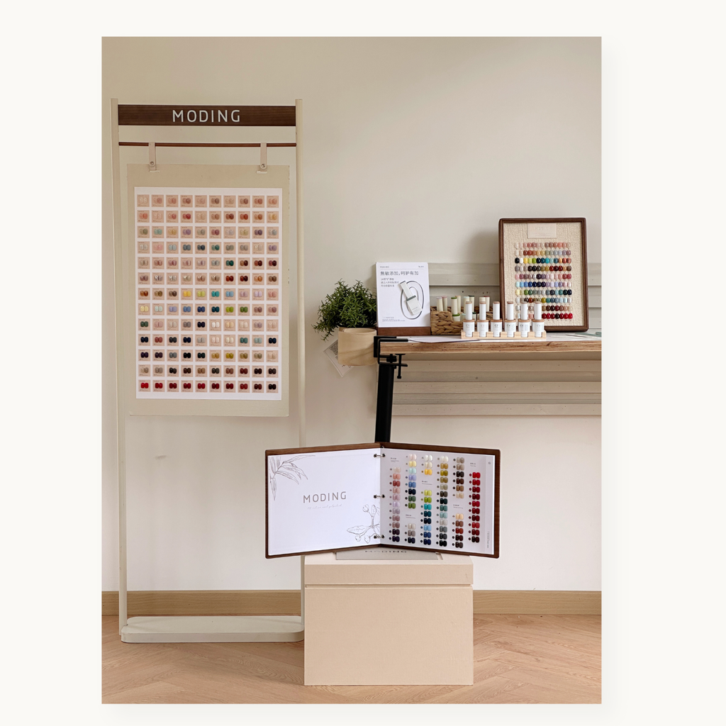 MODING 130-color full set showroom scene with standing color board, framed swatch board, bottle gels, and the large color chart book.