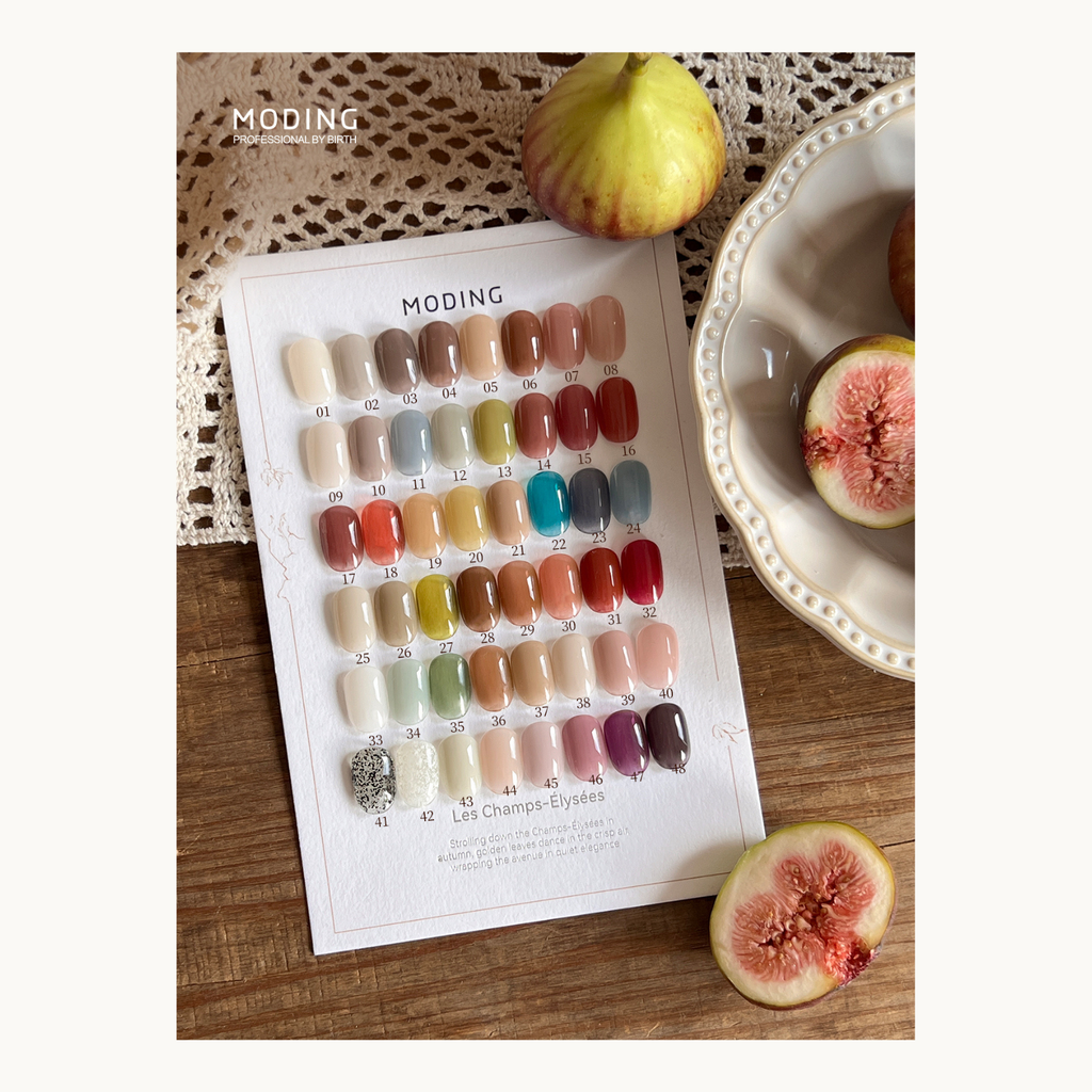 MODING Les Champs-Élysées 48 color nail gel chart displayed with figs and lace, featuring autumn-inspired elegant shades from the healthy HEMA-free collection.