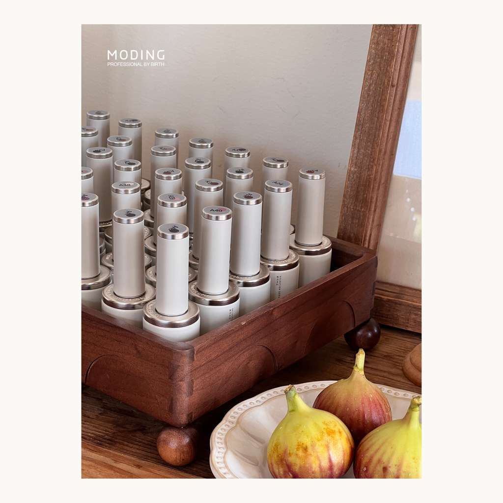 MODING gel polish bottles neatly arranged in a wooden rack, part of the French Champs-Élysées nail collection, showcasing premium healthy HEMA-free nail gel.