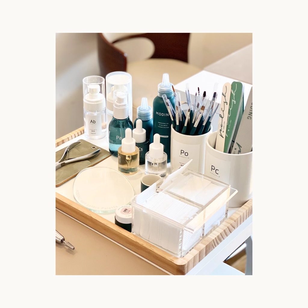 MODING lint-free nail wipes arranged on a nail technician trolley with brushes, liquids, and tools