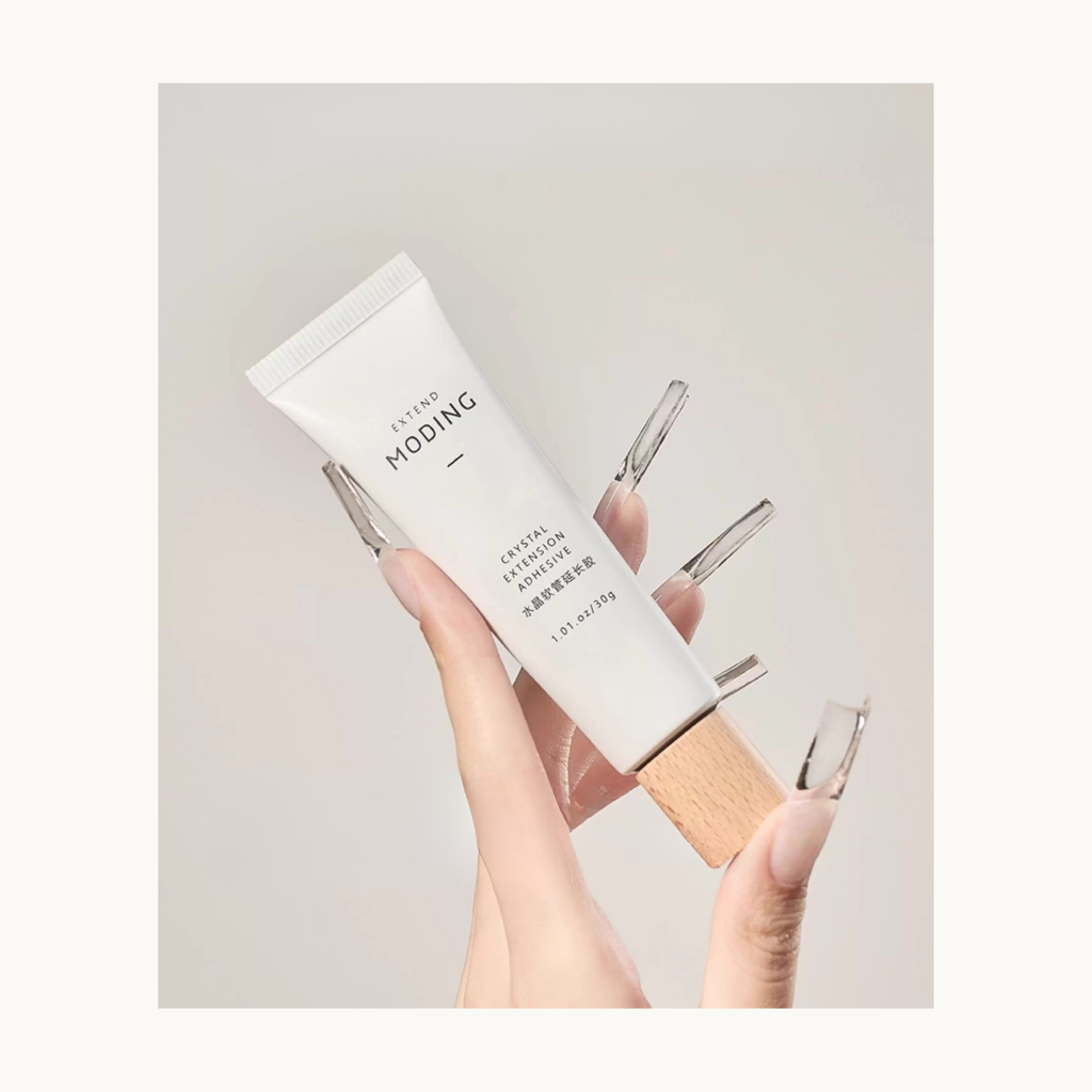 Hand holding MODING poly gel showing clear nails extended using the crystal-clear formula.