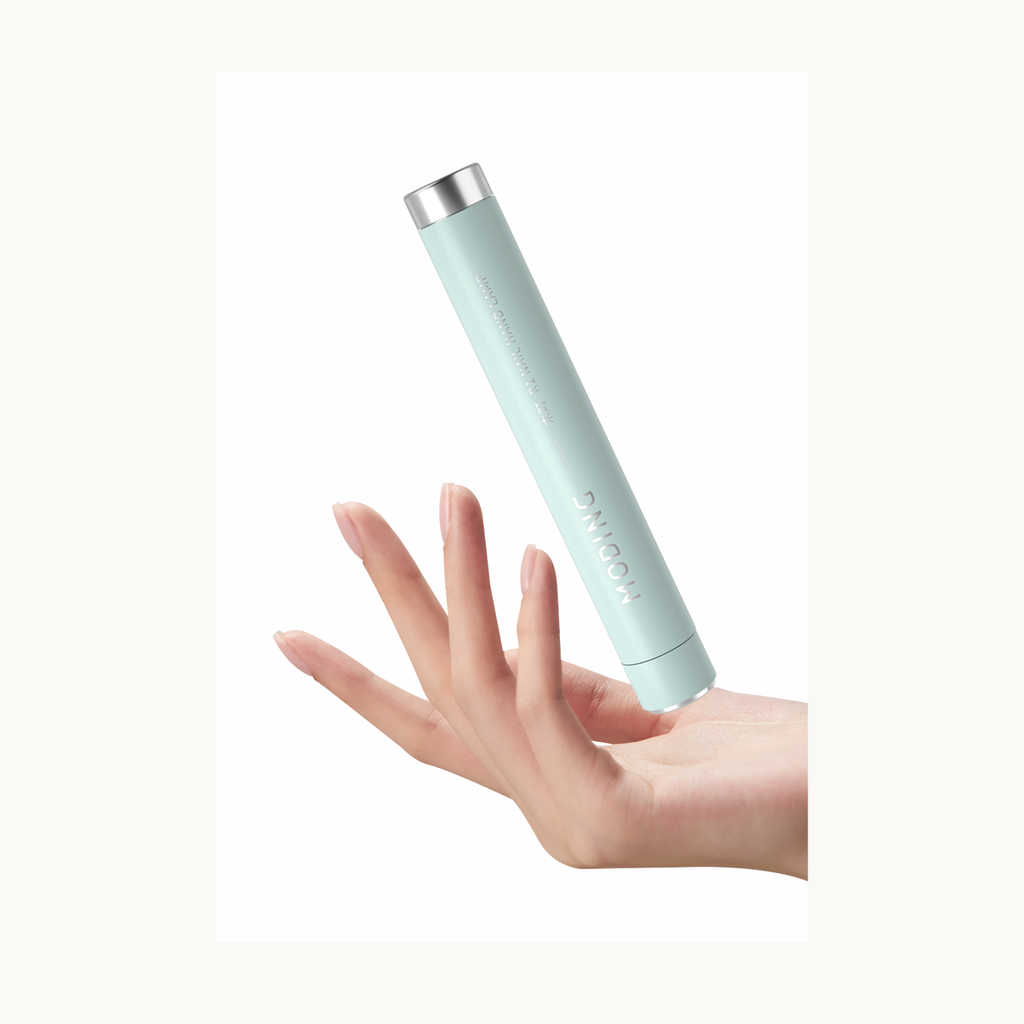 Hand displaying the blue MODING portable nail lamp showing compact and ergonomic design