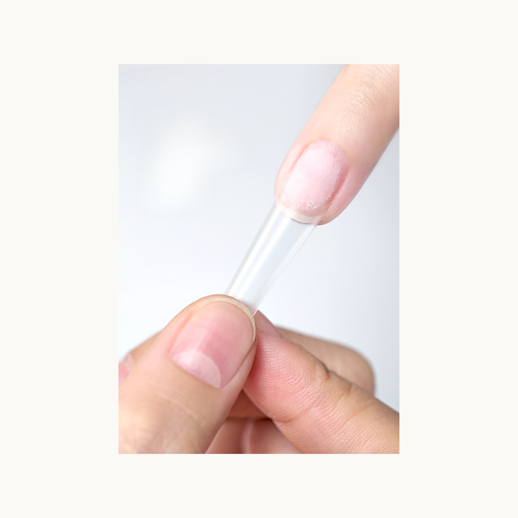 Pressing nail tips onto the natural nail using MODING nail glue for secure bonding