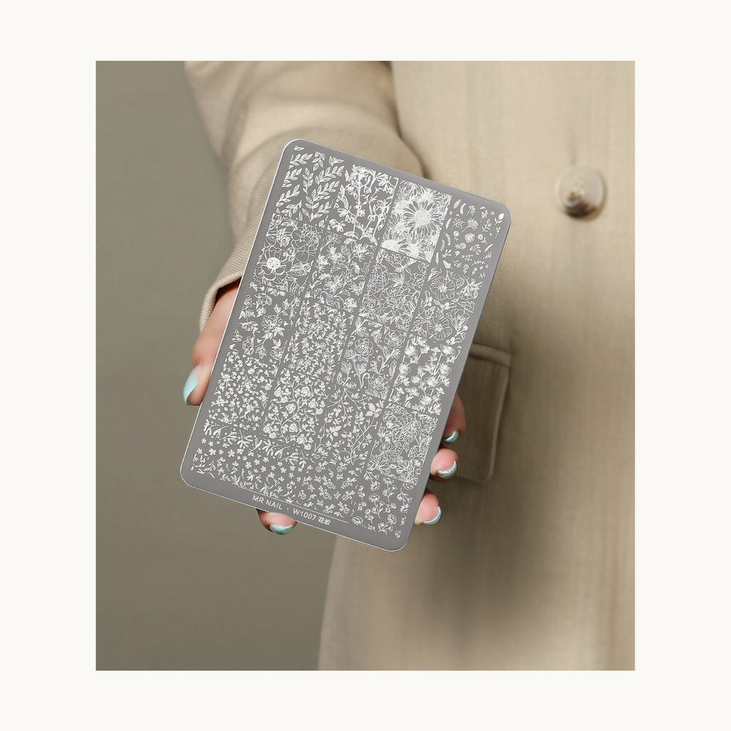 Hand holding MR NAIL W1007 floral nail stamping plate showing intricate botanical designs for nail art