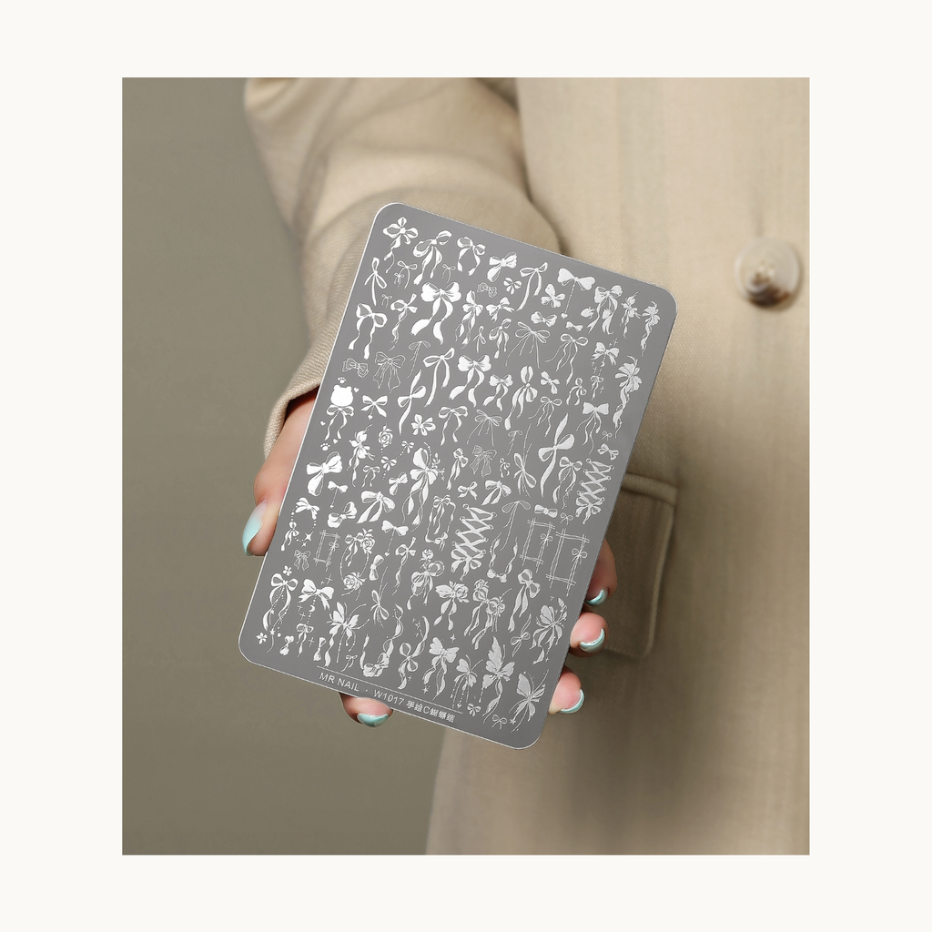 MR NAIL W1017 ribbon nail stamping plate held in hand, showing intricate bow patterns for nail art