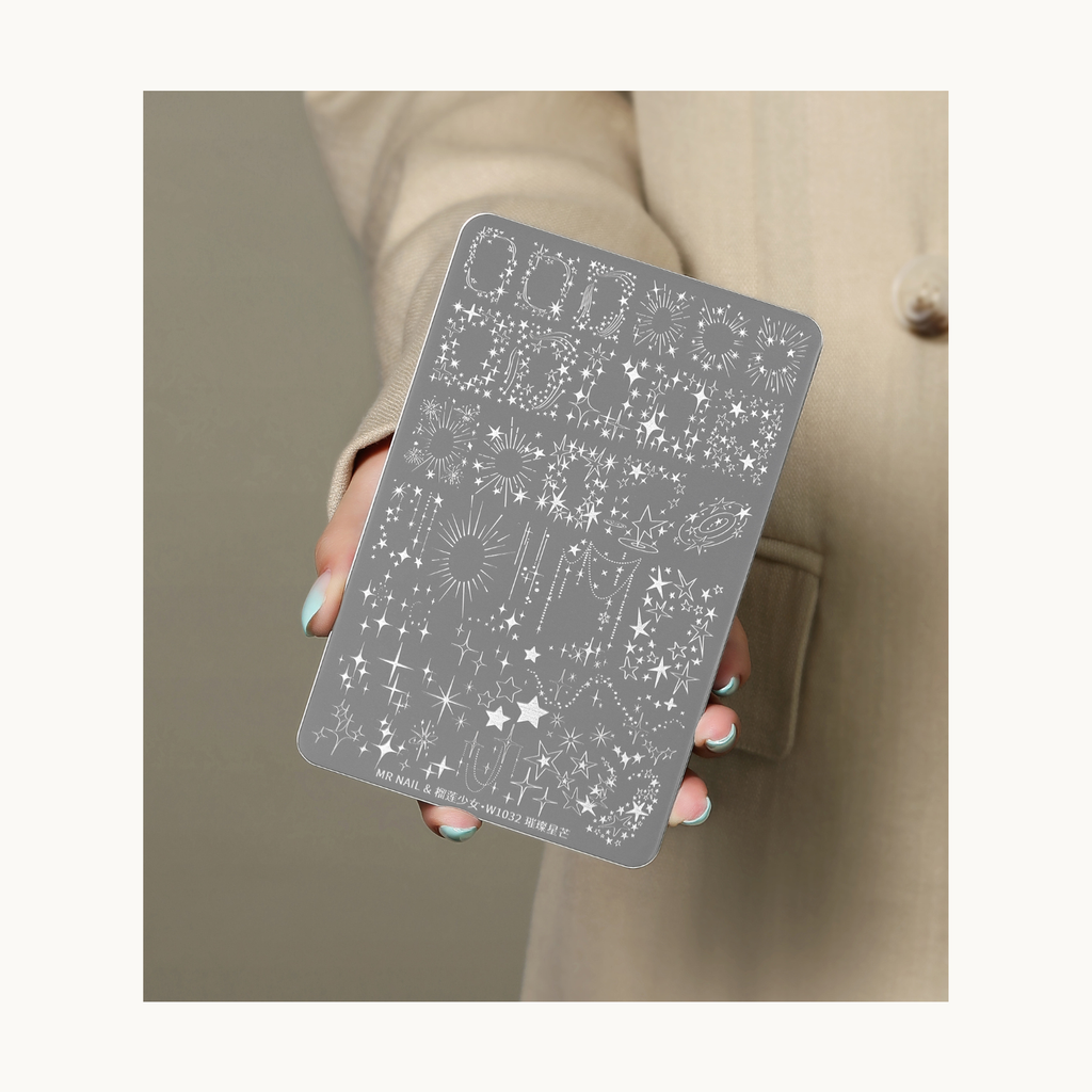 Hand holding MR NAIL W1032 celestial star burst nail stamping plate with galaxy and shimmer star patterns
