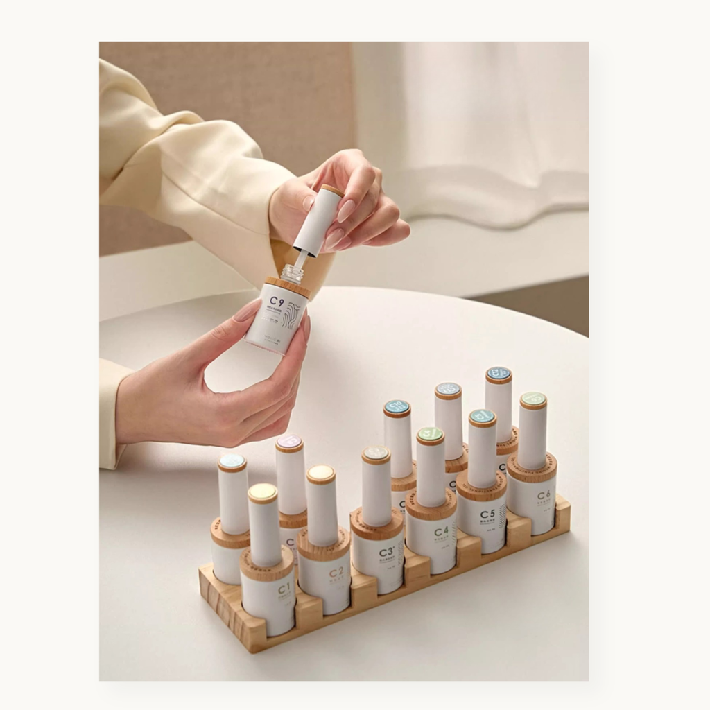 Person holding Moding nail gel bottle with other Moding C-series functioanl gels displayed on the wooden rack 