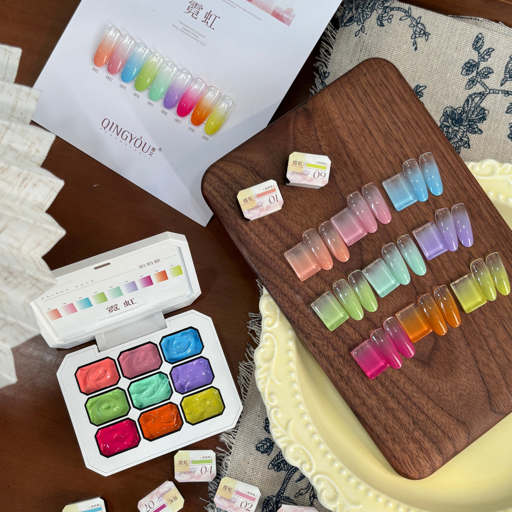 QINGYOU Cube neon paint gel palette with multi-color gradient nail tips displayed on a wooden board and color chart.