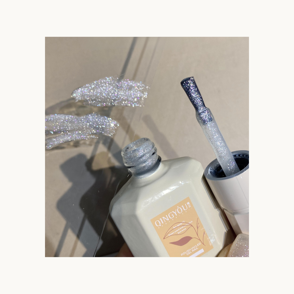 Close-up of QINGYOU White Diamond Glitter Gel on brush showing dense reflective sparkles for layering