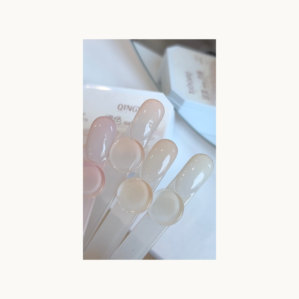 Close-up of QINGYOU nude gel palette showing sheer nude color swatches for gradient nails