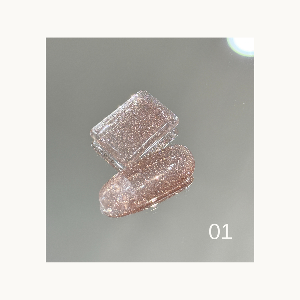 Brush applying rainbow diamond glitter gel showing fine shimmering particles.