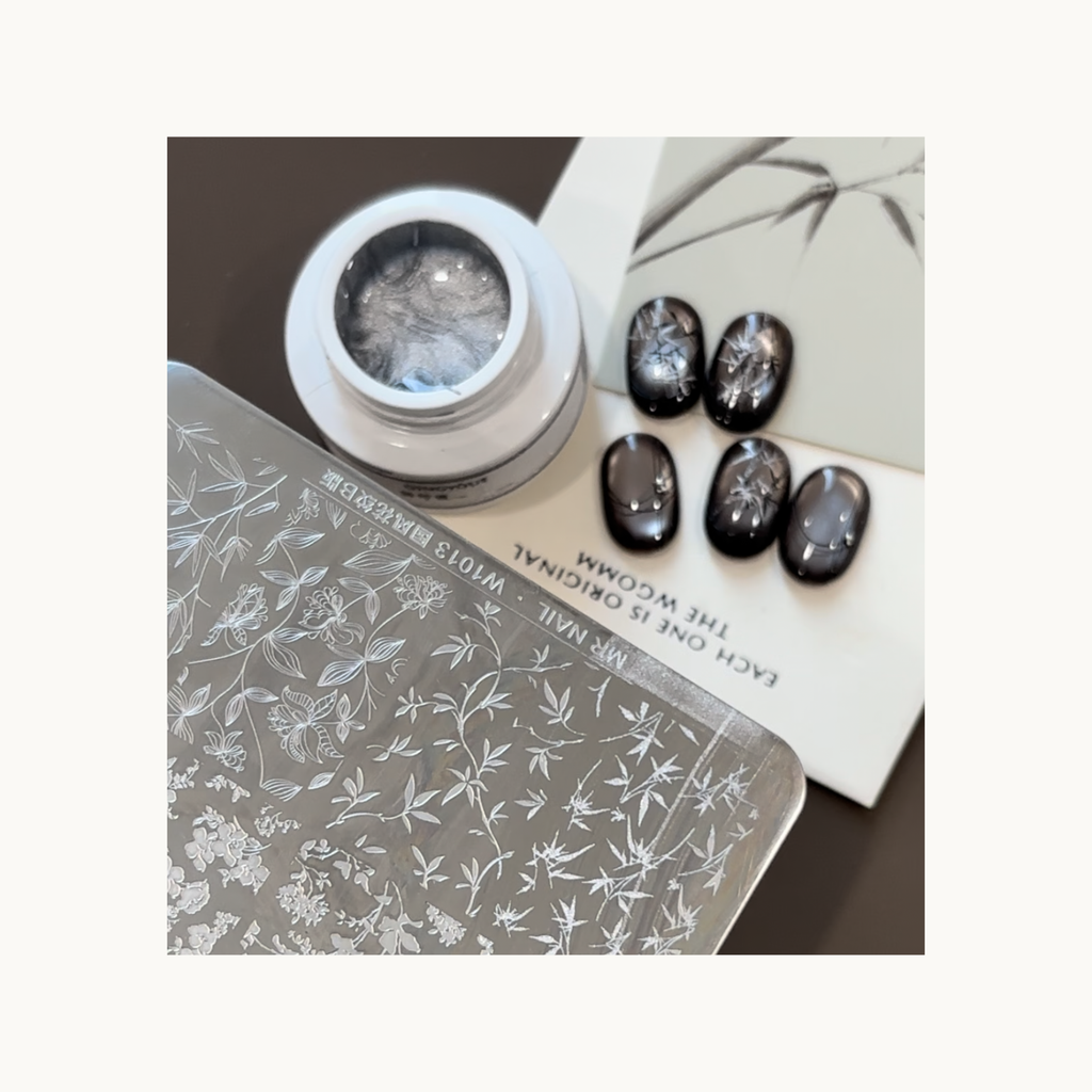 Silver transfer gel stamping on glossy dark nails showing bamboo-inspired ink-wash patterns.