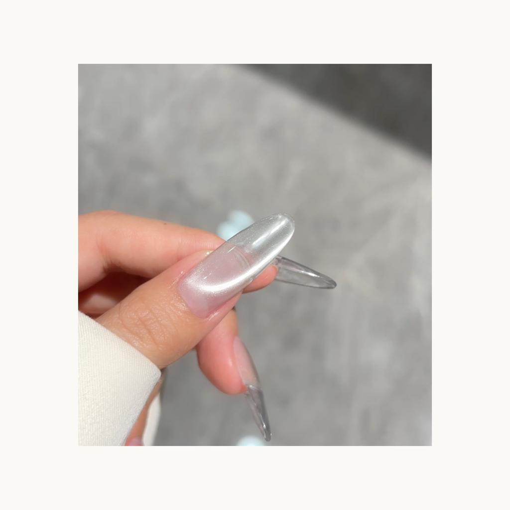Close-up of Qingyou Waterglow White Cat Eye Gel on nail, showcasing bright reflective cat-eye line and glossy finish.
