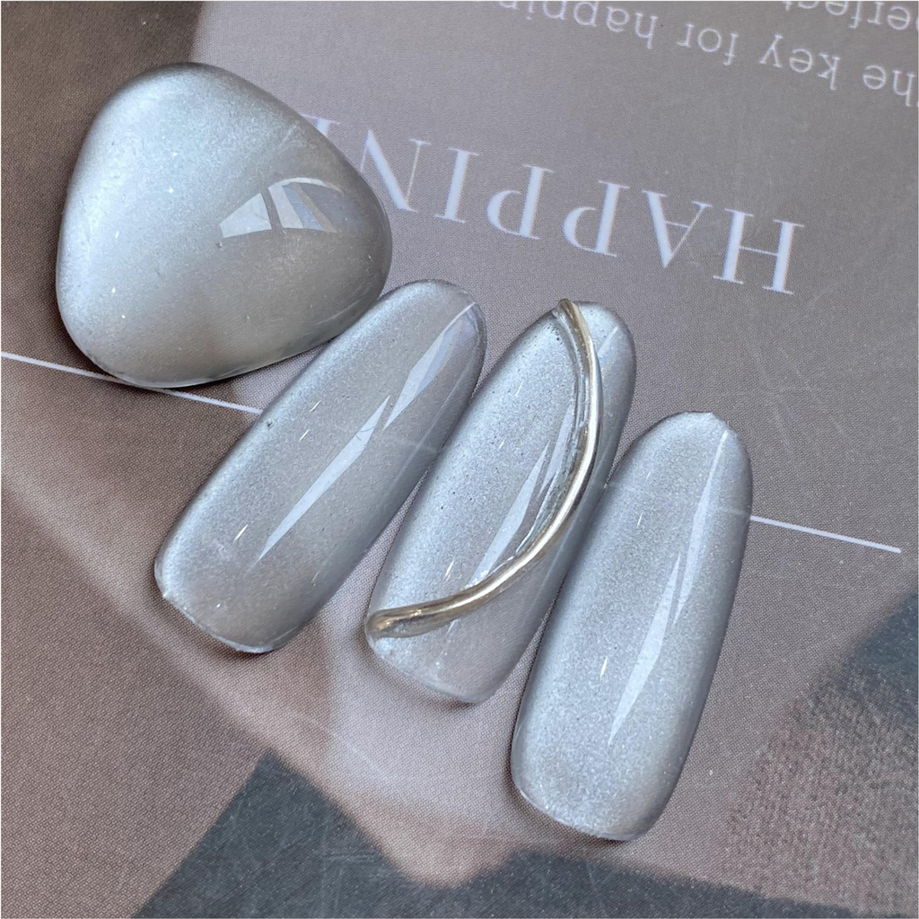 Qingyou Waterglow White Cat Eye Gel swatch showing smooth silver-white magnetic shine, flatlay nail art display.