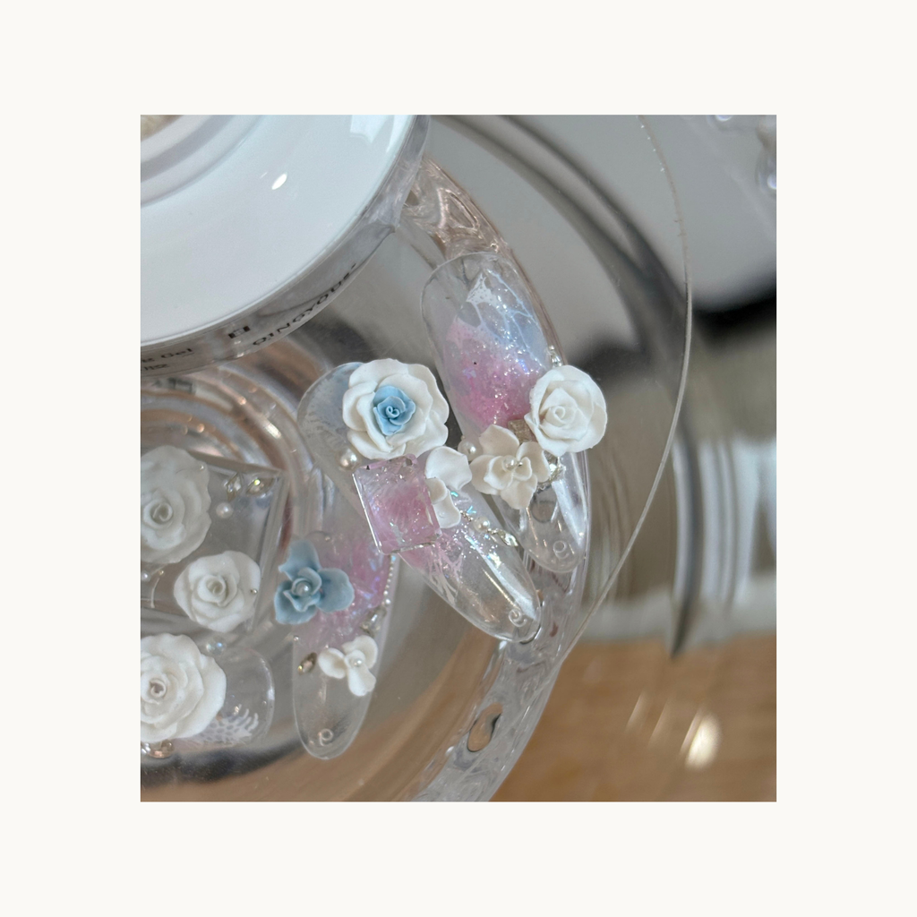 Transparent nail tips with blue and white 3D floral carvings made using QINGYOU carving gel